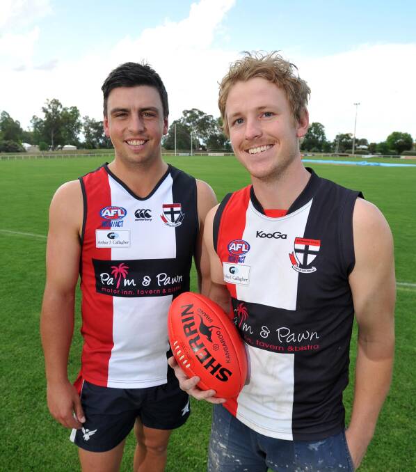 SAINTS TEAMMATES: North Wagga recruits Ned Mortimer (left) and Ryan Dean try on their new strip at McPherson Oval on Friday. Picture: Laura Hardwick