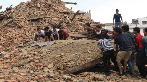 People try to lift the debris from a temple at Hanumandhoka Durbar Square after an earthquake in Kathmandu. Photo: AP