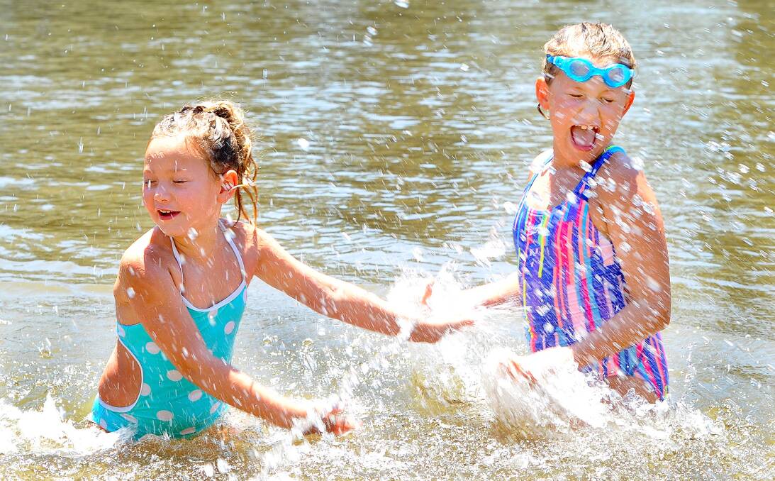 SPLASHING GOOD TIME: Pepper Wilks, 6, and Sydney Wilks, 8, take a dip in the Murrumbidgee River in Wagga to beat the heat on Sunday. Picture: Kieren L Tilly