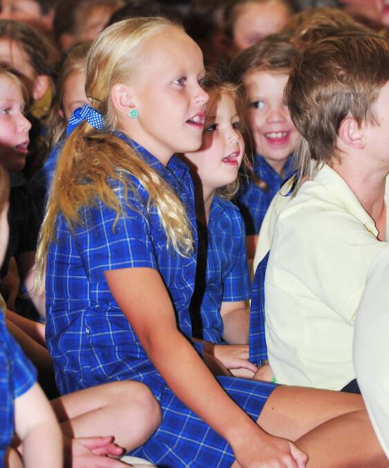 ON SONG: Meg Senior, 11, and Willow Pietsch, 5, watch Amber Lawrence perform at South Wagga Public School. Picture: Kieren L Tilly