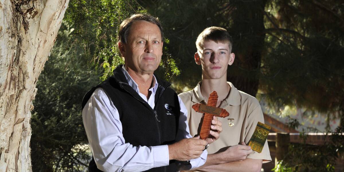 LEST WE FORGET: Kooringal High School teacher Paul Mowbray hands over the cross that his student Matthew Crouch will take to Gallipoli. Picture: Les Smith 