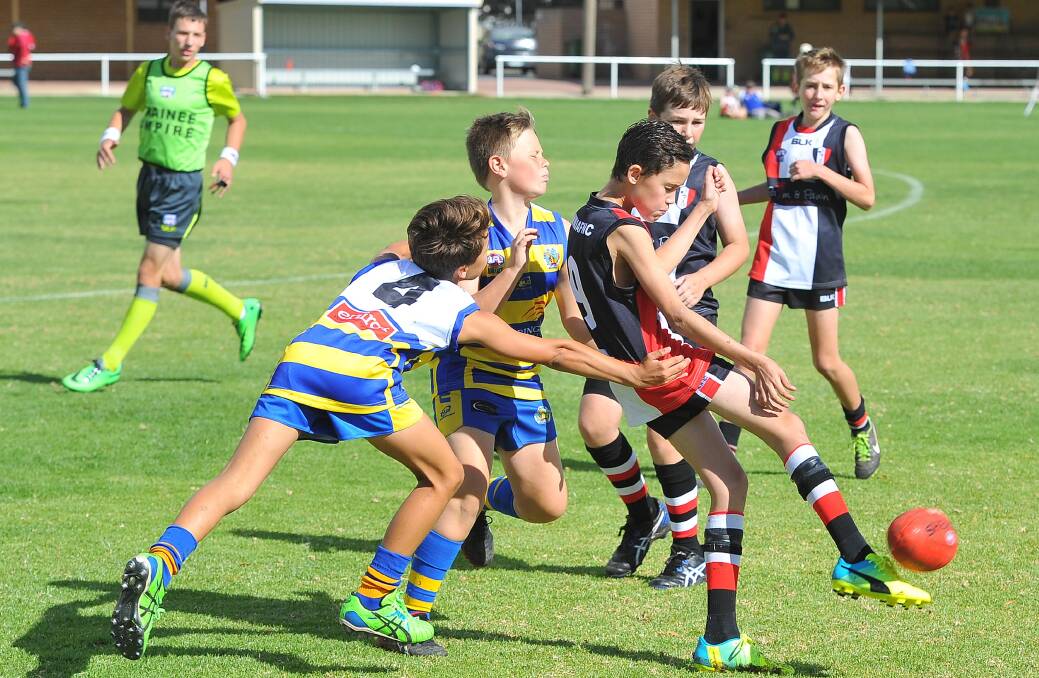 North Wagga's Jacob Sandral gets a boot on it before his MCUE opponents take him down. Picture: Kieren L. Tilly