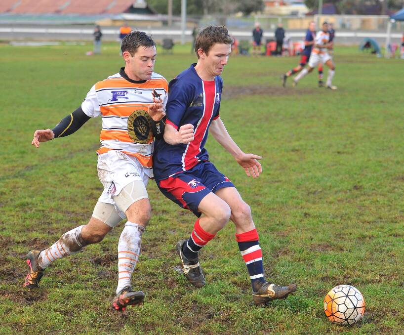 EDGING OUT HENWOOD: At this point, in July, a fifth-placed Wagga United squad could only dream of skipping ahead of then runners-up Henwood Park. Here Ryan McKenzie (left) takes on Chris Hart. Picture: Kieren L. Tilly