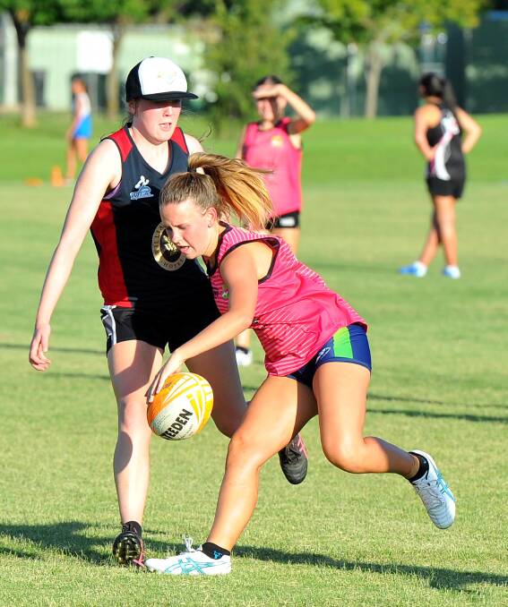 TOUCH AND GO: Cleo Randal keeps the ball rolling for the Young Guns after Starsky and Touch player Sarah Crakanthorp makes a touch at the women's premier league on Tuesday night. Picture: Kieren L. Tilly