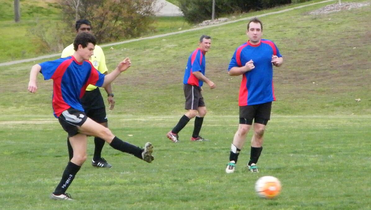WORKING TOGETHER: Nomads midfielder, William Shuttleworth, clears the ball, as his dad, Tom (centre) watches on, as Nomads play Tumut