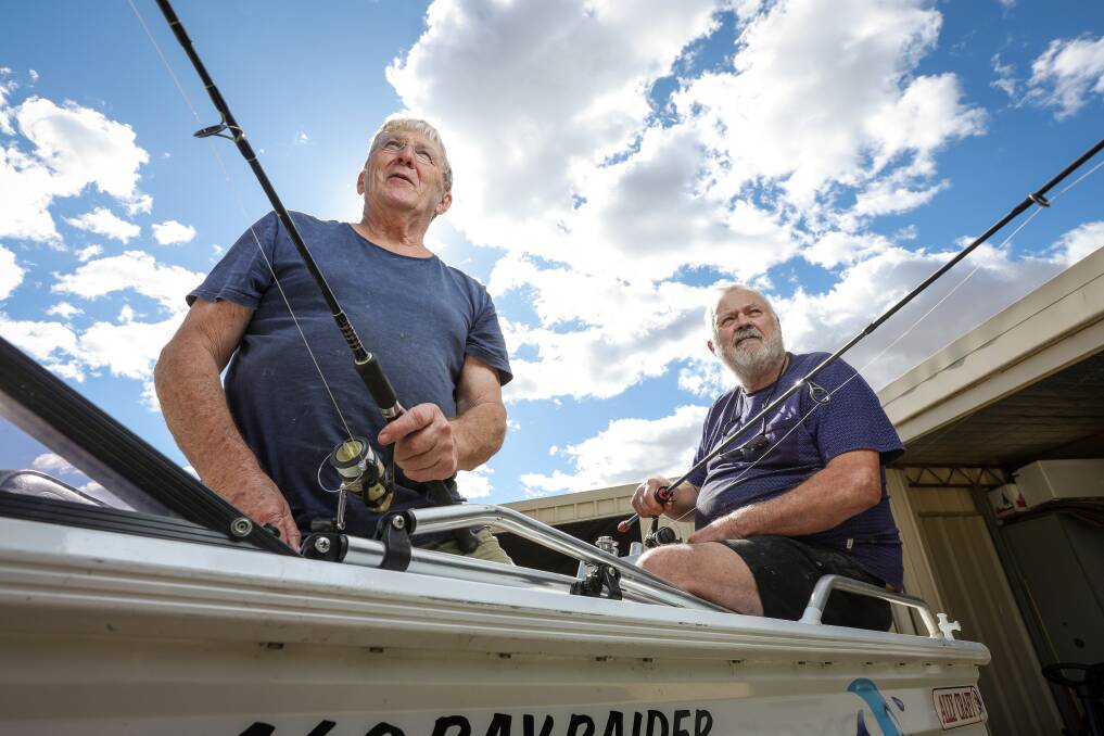 'I can't launch it on my own' ... John Waters, pictured with Barry Dixon, in the fishing boat that's up for sale in this Sunday's Jindera garage sale - along with a "terrific" fly fishing rod. Picture by James Wiltshire