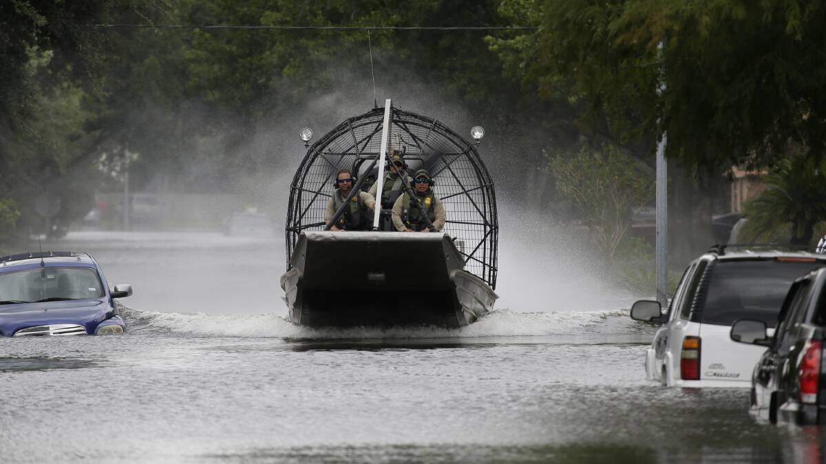 
TROOPS: A US Border Patrol air boat moves through a neighbourhood inundated by floodwaters from Tropical Storm Harvey in Houston, Texas, where crews have rescued more than 450 trapped people this week. Picture: AP
