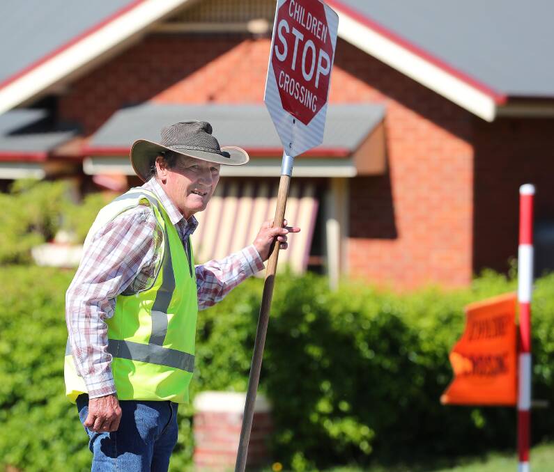 Everyday hero: One school crossing supervisor, Kevin Withers, is never without a smile and a wave as he helps students cross the road outside Kildare Catholic College. Picture: Kieren L Tilly 