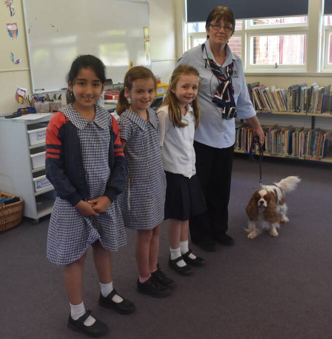 PUPPY LOVE: Raqaya Al-Musawy, Niamh Finucane and Macey Bullock learn about responsible pet ownership with Lindy Morris and the dog Spice. Picture: Lorri Roden