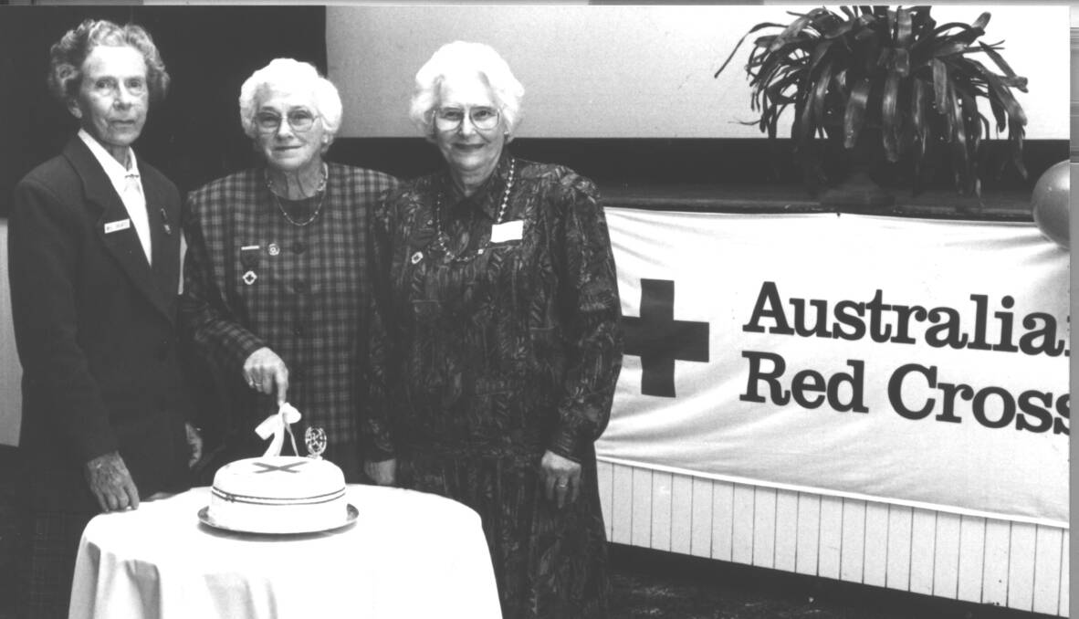 PAST: ​Red Cross, president, Meg Sheaffe, vice-president Shirley Pither and long-term member Ruth Gissing cut the cake in 1997 to mark 80 years of Red Cross Service in Wagga. Picture: Sherry Morris