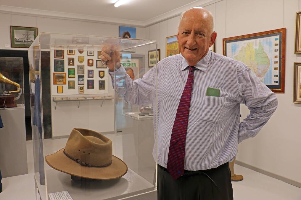 Iconography: Tim Fischer in his self-titled gallery at Lockhart with an Akubra, his mobile phone collection and posters and paintings. Picture: NARRANDERA ARGUS