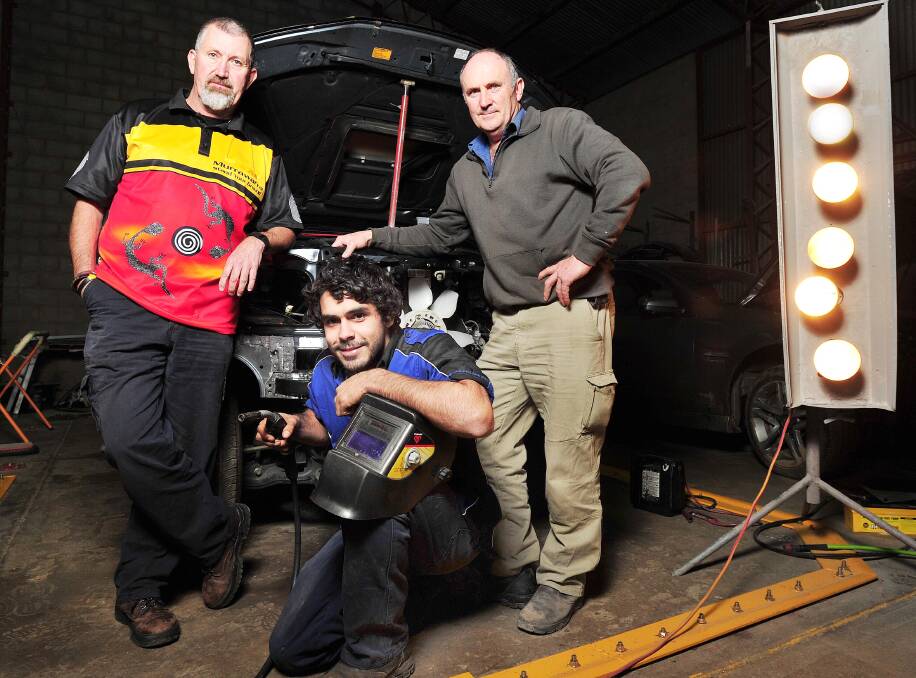 ON TRACK: Tyson Dutton (centre) is busy sinking his teeth into an automotive apprenticeship thanks to help from his boss Craig Glasson (right) and Mark Saddler.