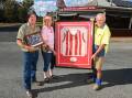Pleasant Hills locals Rick Clancy, Fiona Beckett and Peter Sharp outside the village's community hotel with some memorabilia from the footy club. Picture by Mark Jesser