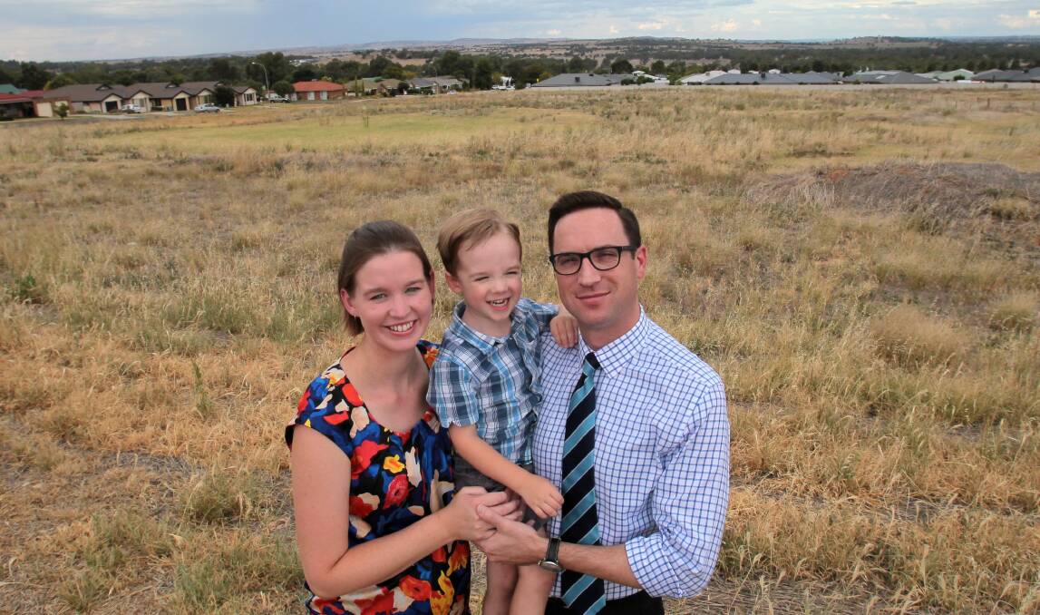 TIME IS NOW: Three-year-old Oliver Cotter with his parents Christina and Graham at the site where land has been earmarked for a future Estella school. Picture: Les Smith