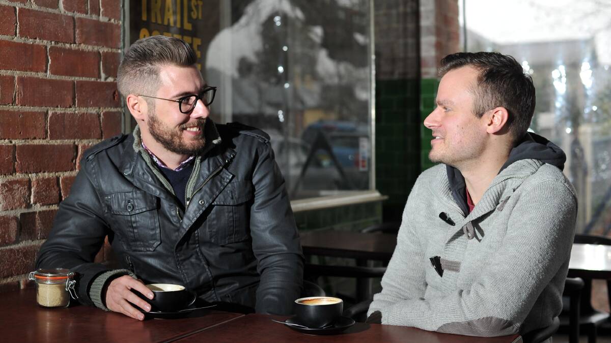 'COME AND TALK TO US, KEITH': Wade Kelly and Philip Paschke, who married each other in Canada, enjoying a coffee together on Wednesday. Picture: Laura Hardwick