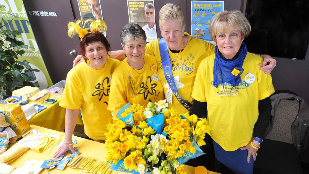 ALL YELLOW: Carolyn Shawe embraces volunteers (from left) Dorothy Ceeney, Barbara Brewer and Noreen Tuckwell at the Commercial Club stand. Picture: Laura Hardwick