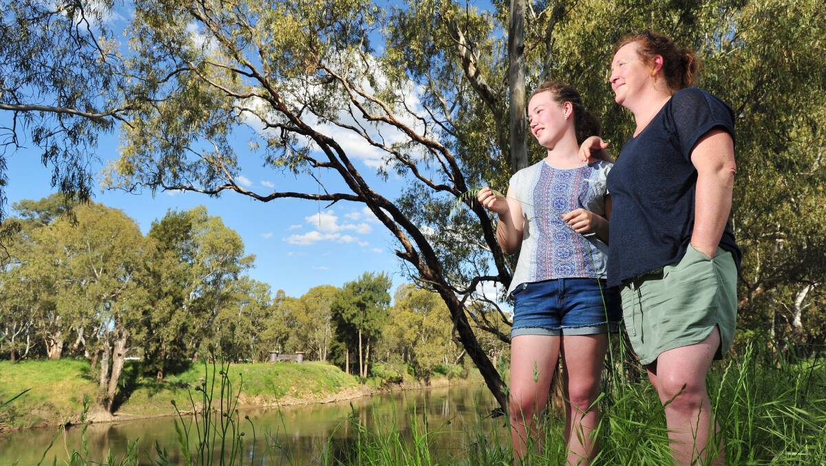 ONLY WAY IS UP: Wagga's Lucy Miegel, 15,  and Jenny Woods by the Murrumbidgee River, where council has its targets 'locked' on governments for more levee funding. 