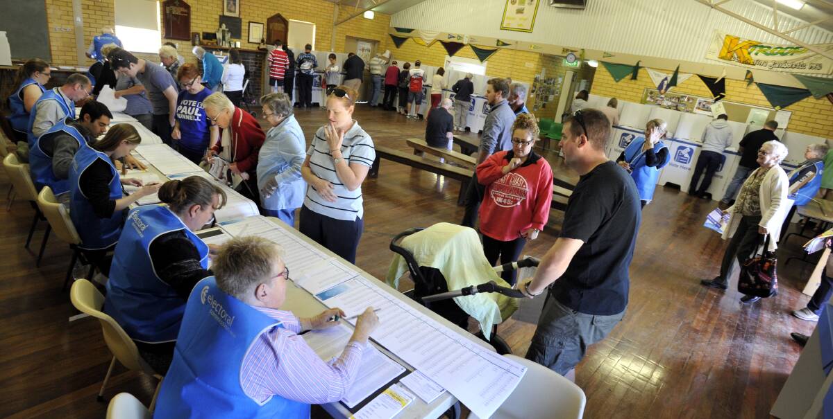 VOTE 1: Voters pick up their ballot papers at Glenfield scout hall, while a CSU academic claims rural people are less likely to be swinging voters. Picture: Les Smith