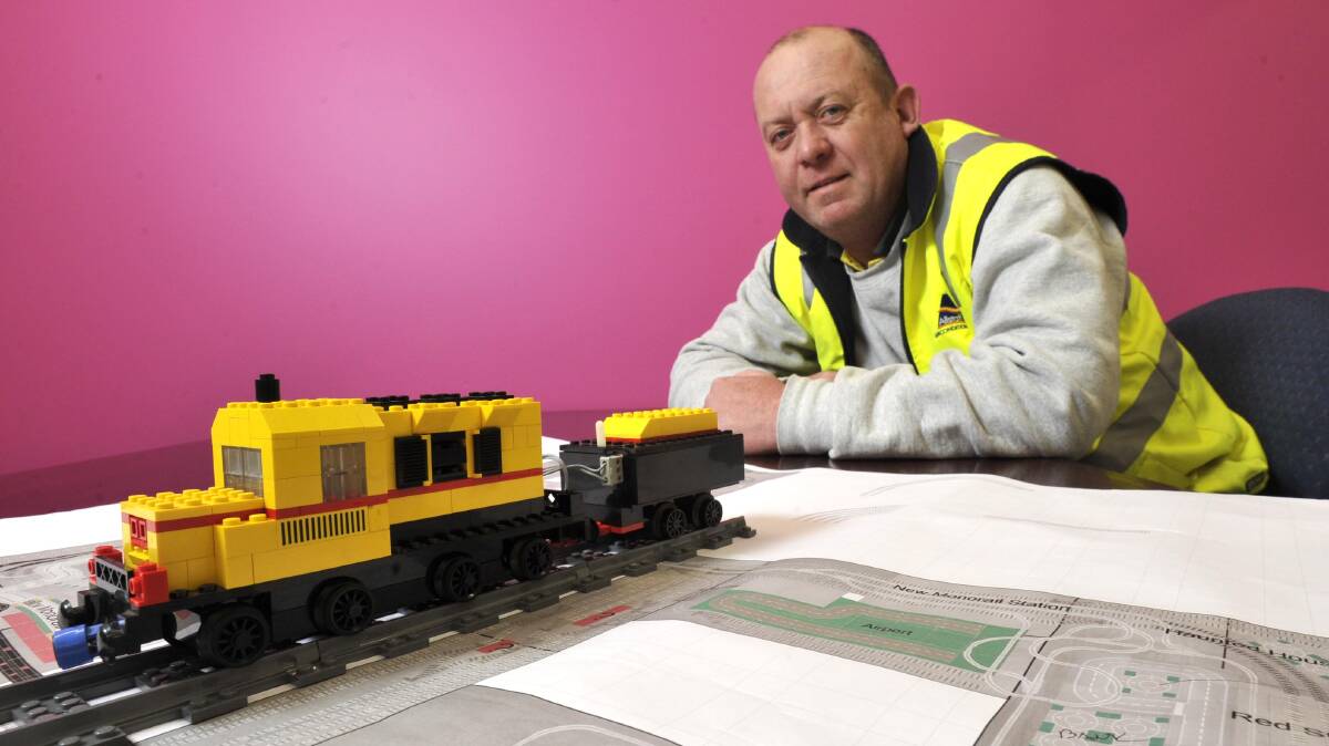 KEY TO LIFE: Enthusiast Nathan Hauser shows off the plans and a vintage locomotive to be used in his Lego exhibit next month. Picture: Les Smith 
