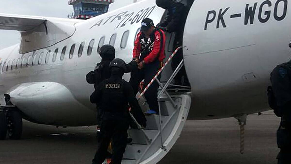 Andrew Chan is escorted by heavily armed police as he disembarks the plane. Picture: Fairfax