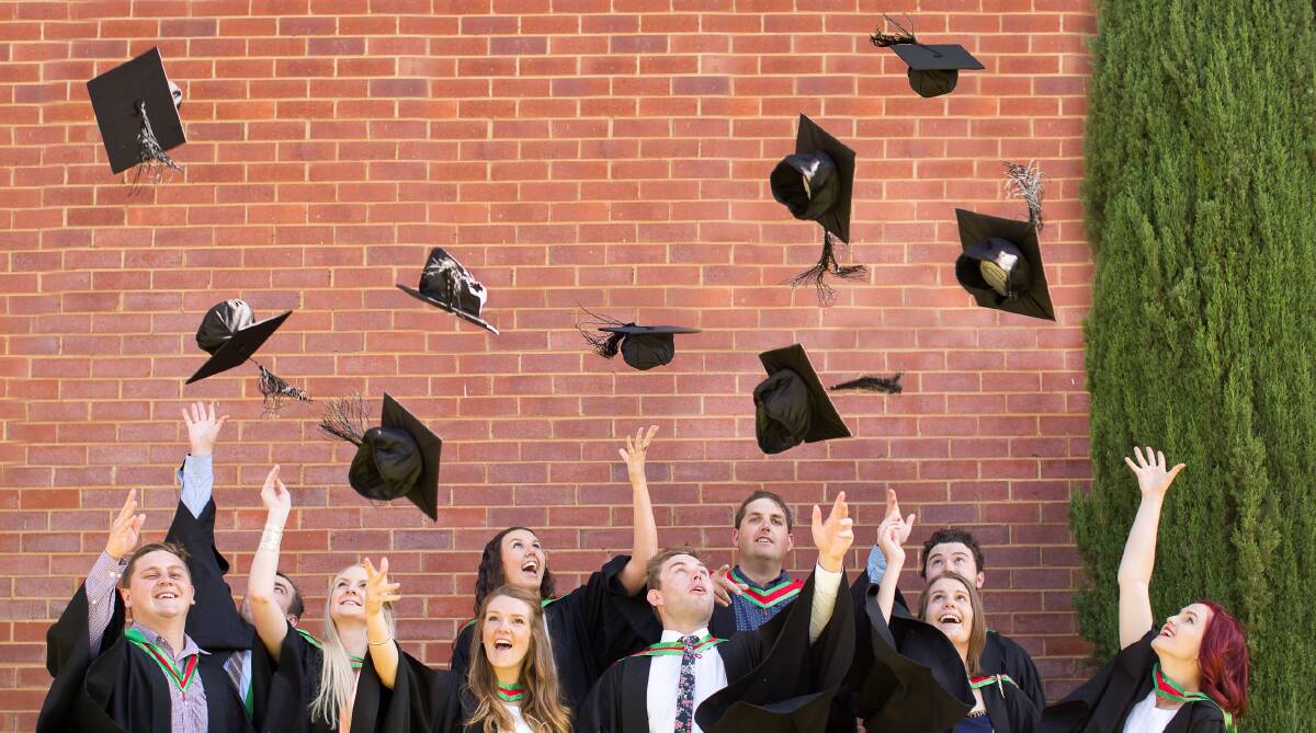 HATS OFF: Wagga Charles Sturt University students celebrate their graduation last year. A UK university has banned the traditional mortarboard toss.