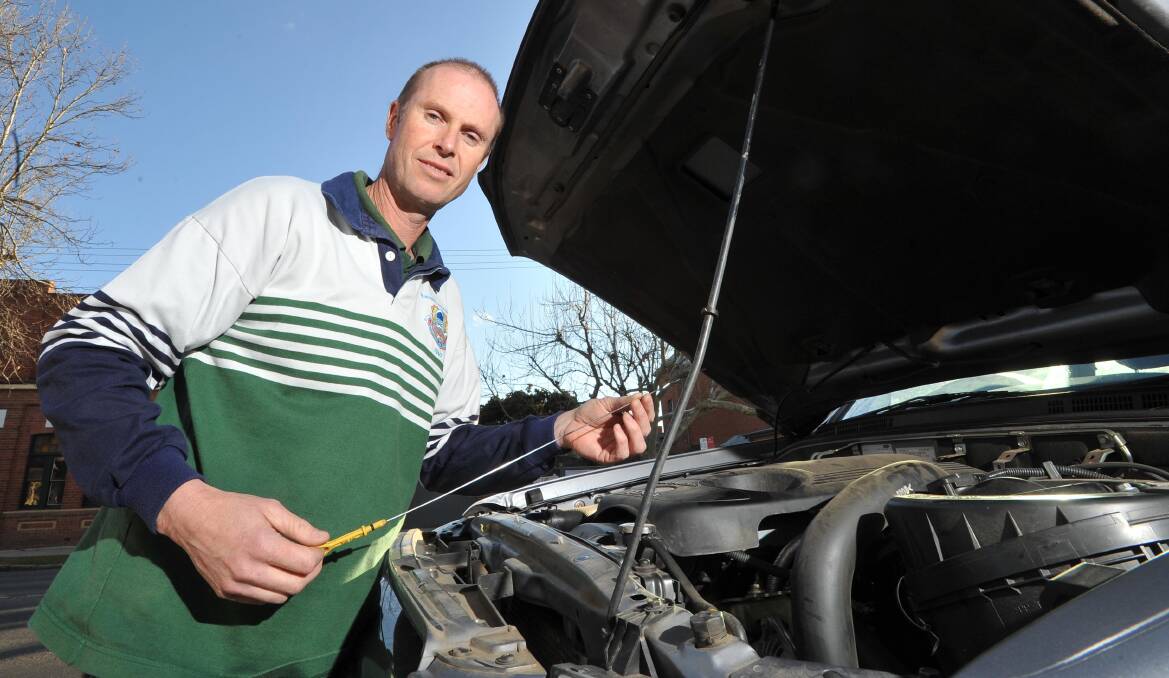 CHECK LEVELS: Wagga and District Car Club vice-president Jason Wall checks his oil. Picture: Laura Hardwick