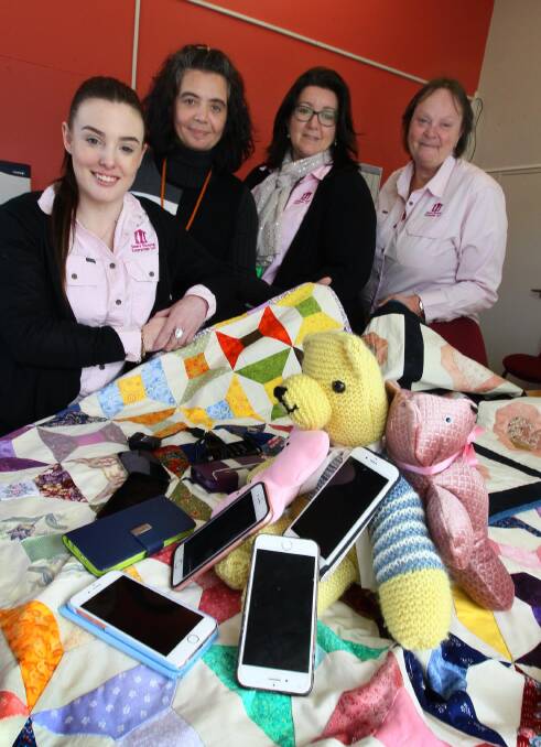 DONATIONS: Alex Quarmby, Andrea Schineanu, Tammy Bugg and Belinda McMahon with phones, and items from Wagga Patchwork and Quilters Group. Picture: Les Smith