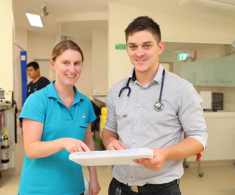 Pharmacist Angela Adams discusses a patient's medication requirements with Daniel Frawley.