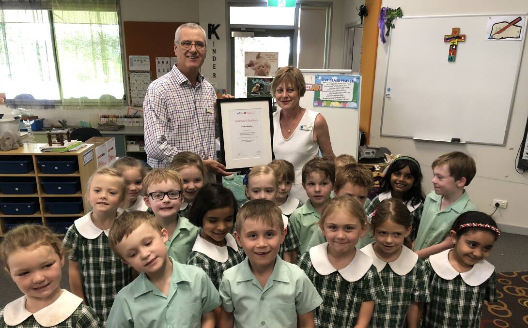 WELL DONE: Lutheran School Wagga's Karen Suckling is commended on her national award by principal Peter Weier and her students.