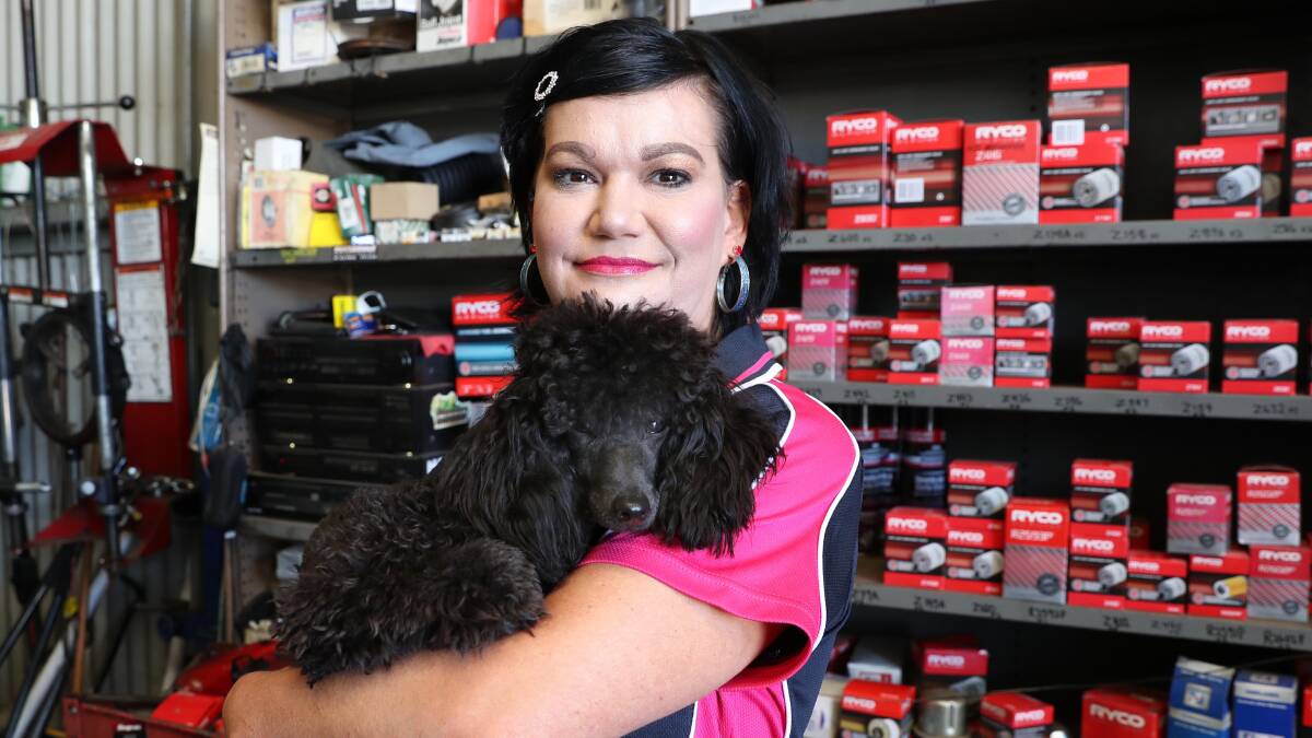 WORKOUT TIME: Encore exercise program facilitator Kate Christie, with pet Bailey, at work in the family mechanical repair business. Picture: Les Smith