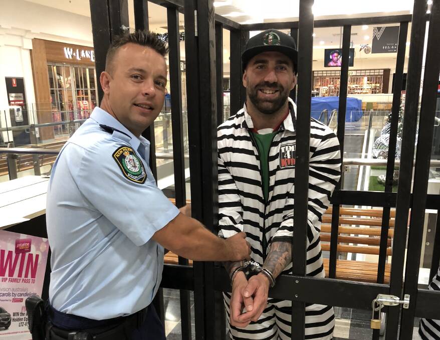 BEHIND BARS: Senior Constable Jovica Buinak "arrests" Braydon Sharrock from Wagga Brothers, who is also a police officer.