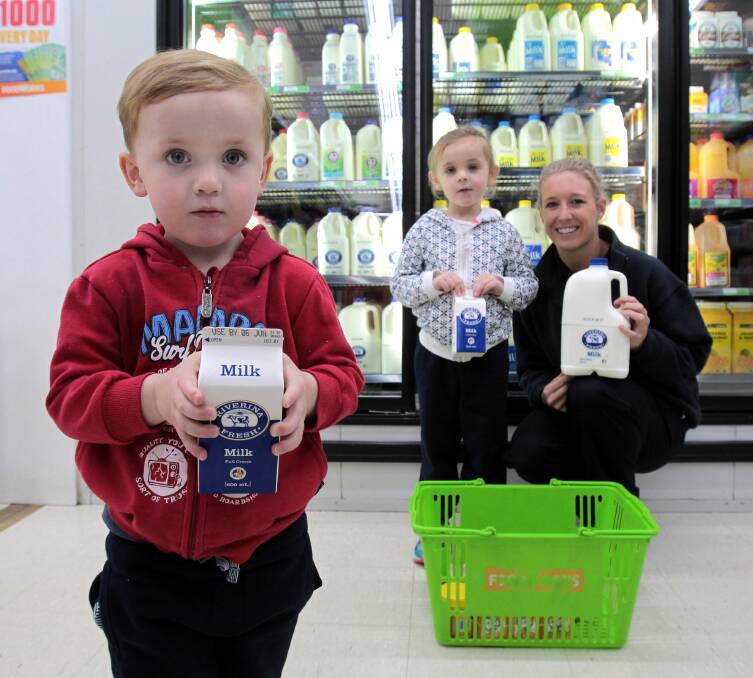 FARMER FRESH: Nate Bradley, 3, Molly Bradley, 4, and Foodworks Lake Albert manager Bailey Porter show their support for local milk.