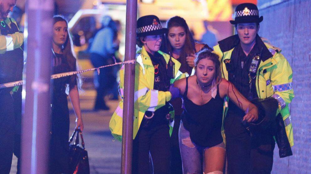 MUSIC DIES: A young girl is helped from the Manchester Arena, where a suicide bomber murdered 22 people. Picture: Fairfax Media