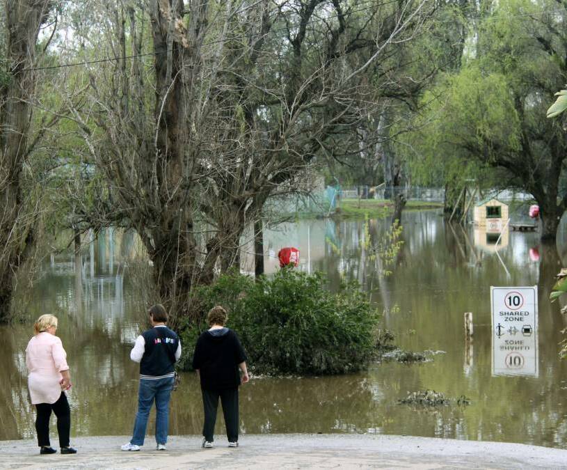 DOWN UNDER: Baffled residents watch on as a carpark near Wagga Beach is completely submerged by the Murrumbidgee River. 
