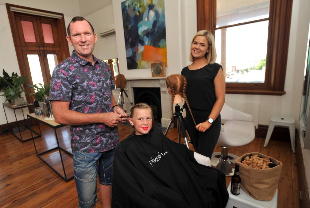 Skilled: Father of six girls Bill Robertson is well practised doing hair, pictured with two of his daughters Grace and Mariah. Picture: Laura Hardwick.
