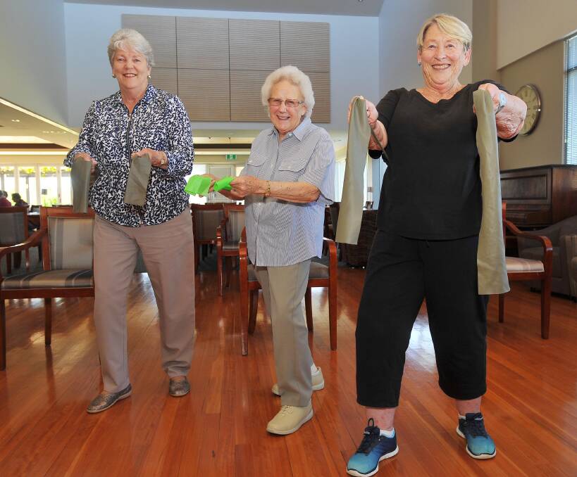 LET'S GET PHYSICAL: Retiree fitness devotees Helen Beveridge, Pat Green and Jan Marsh get ready for some stretching practice during a weekly class at The Grange. Picture: Kieren L. Tilly