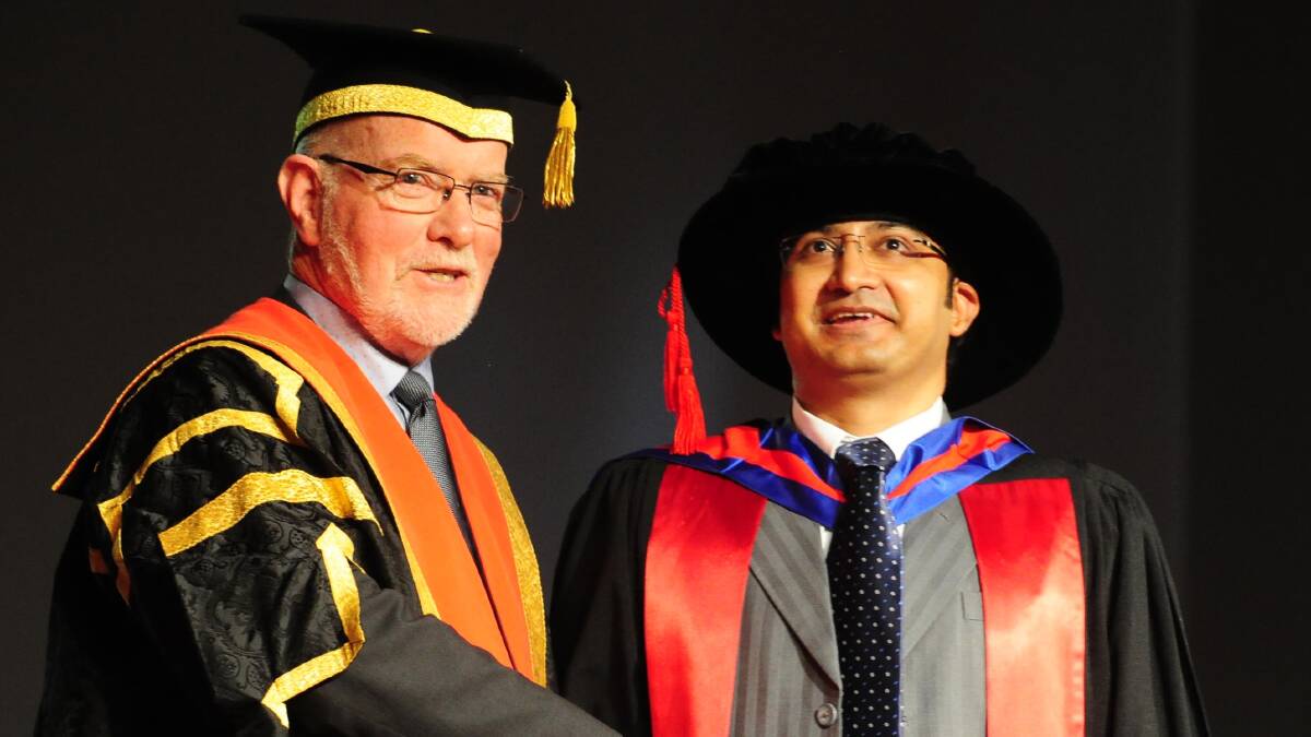 DISCOVERY:  Deputy Chancellor Peter Hayes congratulates Dr Syed Haris Omar at a graduation ceremony on Friday. Picture: Kieren L Tilly.