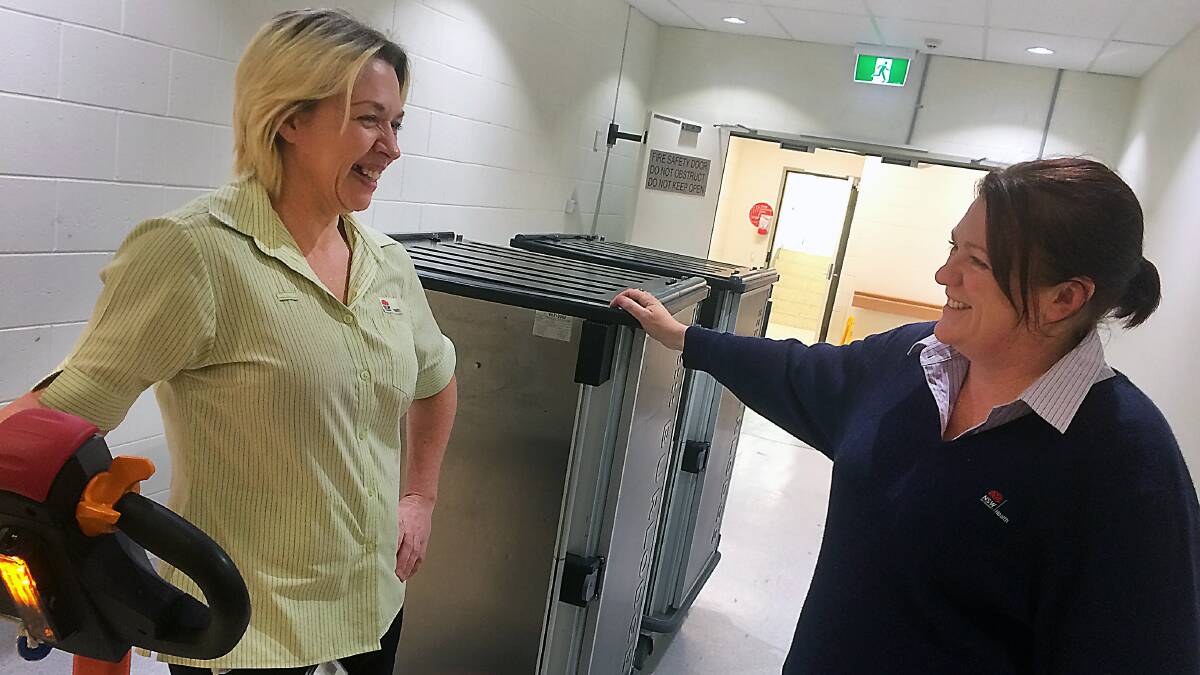 Fiona Howard stops her motorised "tug", which is towing some of the "Burlodge pods", to chat with food supervisor Shellie Lawlor.