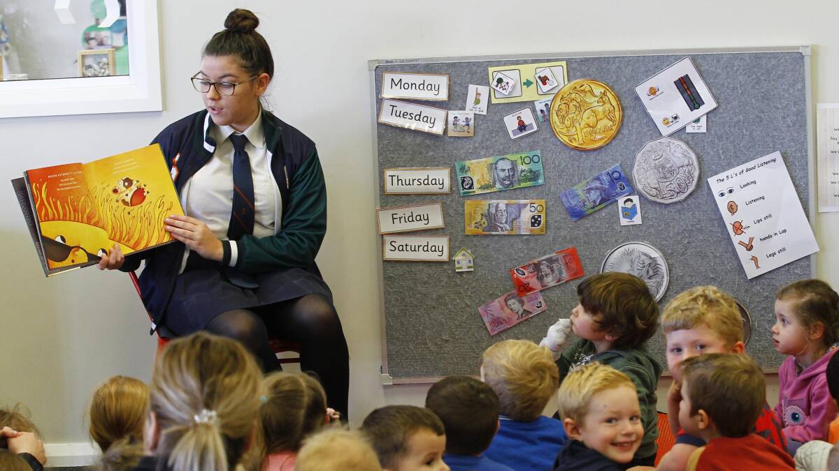 Kids at Wagga's Early Years Learning Centre sit down with students from The Riverina Anglican College for a story. 