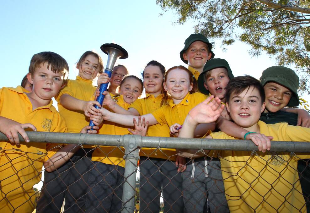 FLAME OF HOPE: Kids at North Wagga Primary meet the Peace Run relay team at the gate. Picture: Les Smith