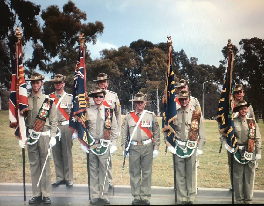 BATTALION COLOURS: Ensigns carry the battalion colours with their armed escorts. WOII Mason is second left.