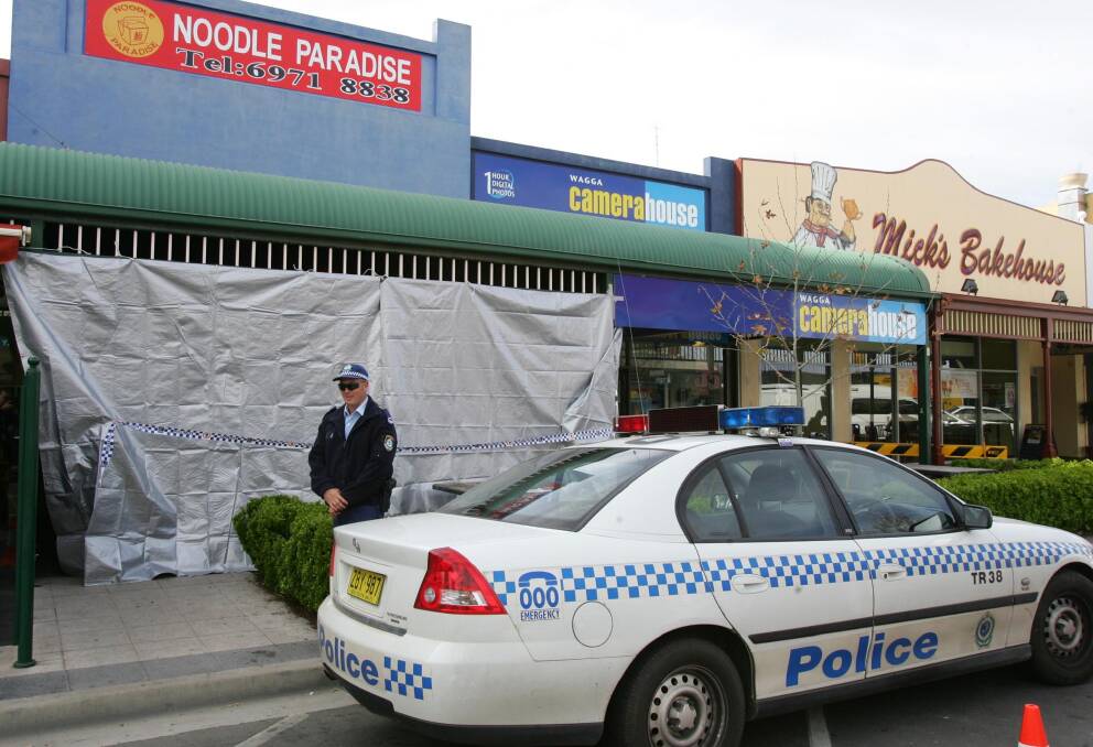 CRIME SCENE: A police officer stands guard over the crime scene at Noodle Paradise in September, 2006