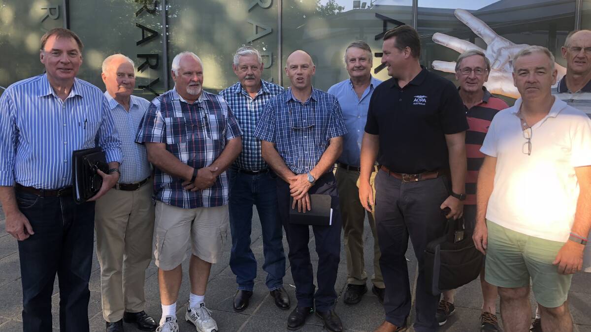 HIGH-FLYERS: A satisfied Geoff Breust (far left) with members of the Wagga City Aero Club following council's decision to retract overnight parking fees at Wagga Airport. 