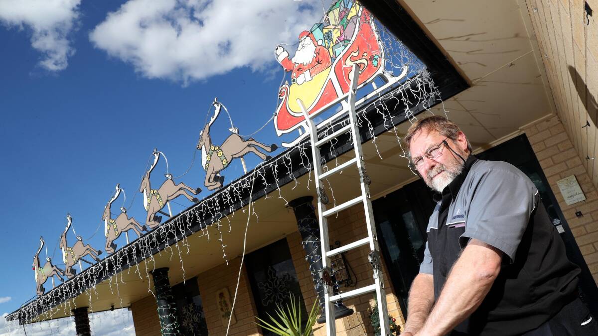 DECK THE ROOF: Robert O'Brien has been spending quality time up the ladders making ready for yet another year of Lyndoch Place Christmas cheer. There's still more to go on the roof, apparently. Picture: Les Smith