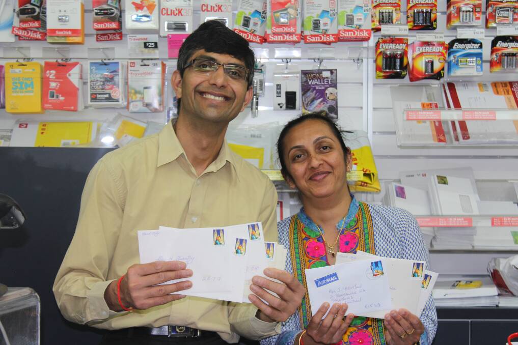 CHRISTMAS CORRESPONDENCE: Himanshu and Bhakti Rawal have been inundated with Christmas letters and parcels at the Ashmont Post Office. Picture: Lachlan Grey