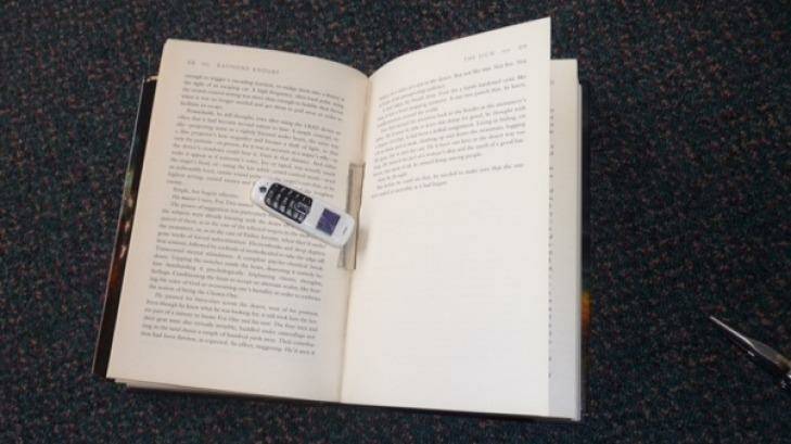 The phone discovered inside the spine of a book earlier this month. Photo: Corrective Services NSW