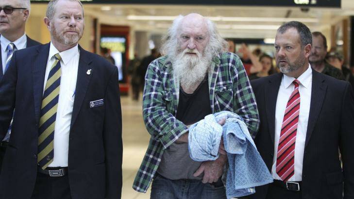 Colin Michael Newey is escorted through Sydney Airport by police after being extradited from South Australia. Photo: Janie Barrett