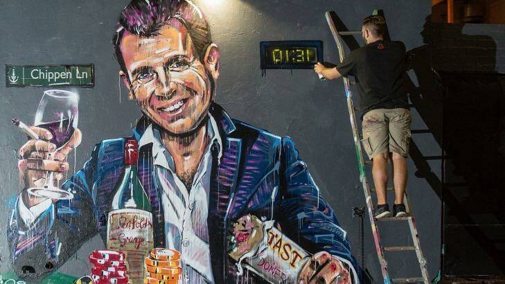 Artist Scott Marsh paints a mural of NSW Premier Mike Baird holding a kebab and glass of wine surrounded by poker chips. Photo: Cole Bennetts/Getty Images