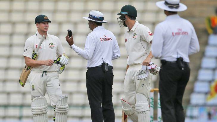 Australia's Steve Smith speaks with umpire Sundaram Ravi as the light fades on day four of the first Test between Sri Lanka and Australia. Photo: Eranga Jayawardena