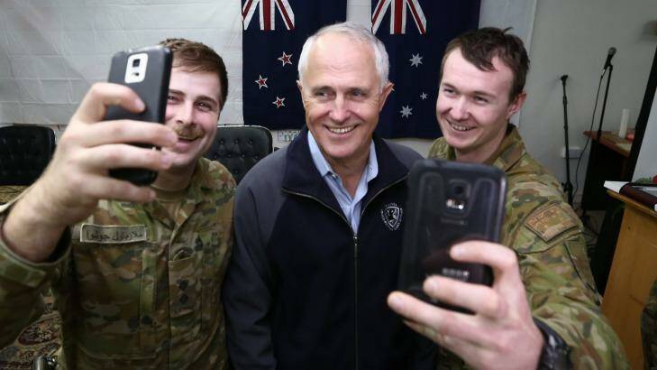 POOL PHOTO: Prime Minister Malcolm Turnbull poses for "selfie" photos with Lieutenant Joshua Armstrong (left) and Lieutenant-Corporal Lincoln Pade (right) during his visit to Taji Military Complex in Iraq.  Photo: Alex Ellinghausen